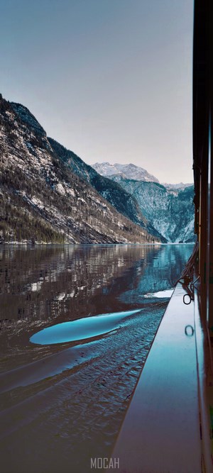 Boat wake on a lake with snow-capped mountains