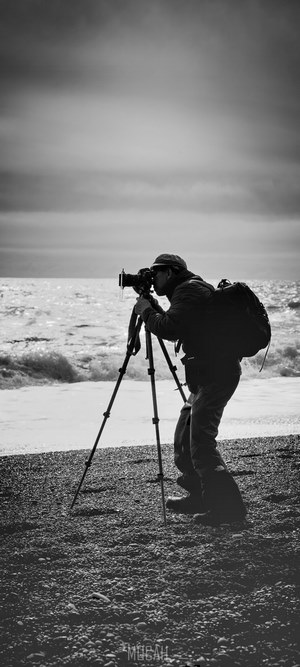 Photographer with tripod on a beach