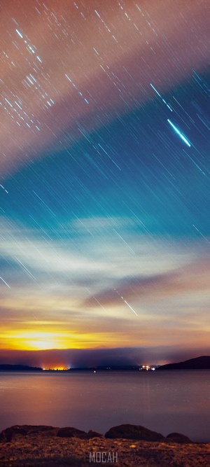 Star trails over a lake at sunset