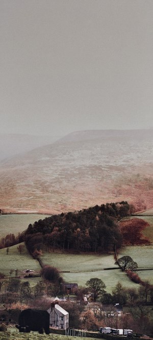 The Peak District landscape with a farm and trees