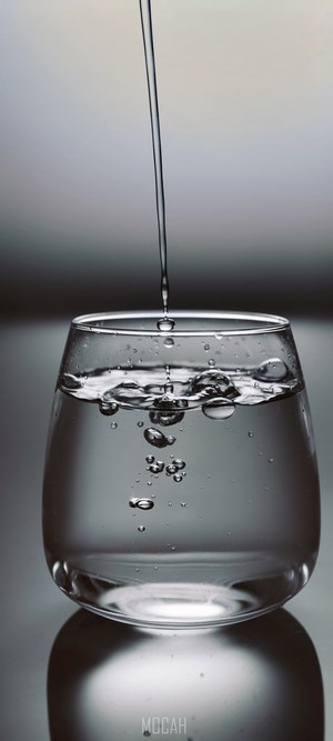Water pouring into a glass with bubbles