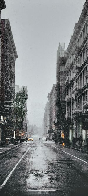 Snowy City Street with Buildings and Cars
