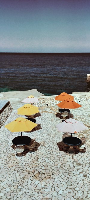 Outdoor seating area with umbrellas by the sea