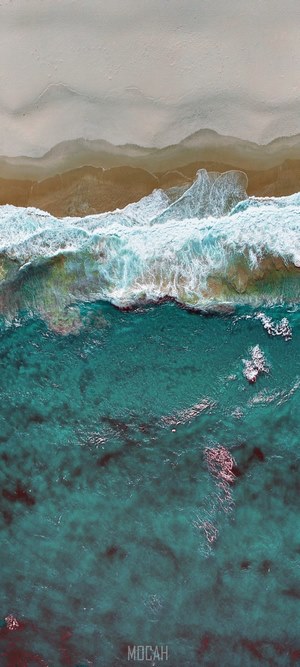 Aerial view of ocean waves crashing on a sandy beach