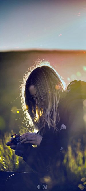 Girl with camera in backlight