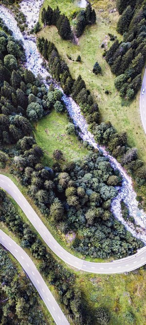 Aerial view of a winding road and river in the Swiss Alps