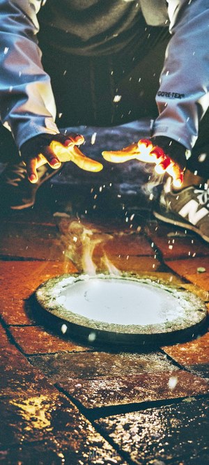 Hands over a heat source with sparks