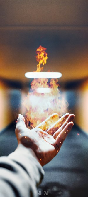 Hand conjuring fire with light in background