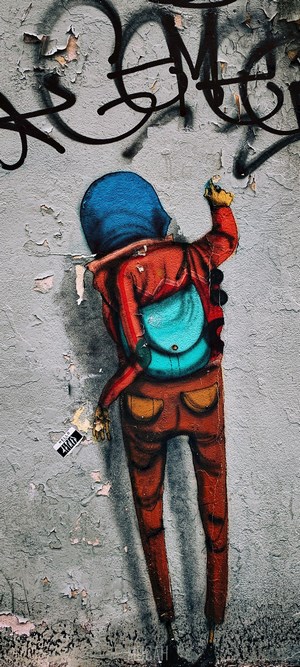 Graffiti art of a person painting on a wall