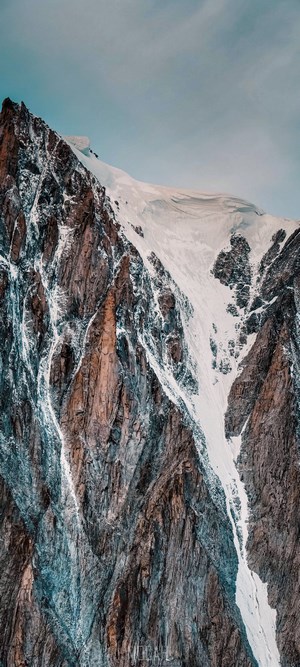 Snow-covered mountain range with rocky slopes