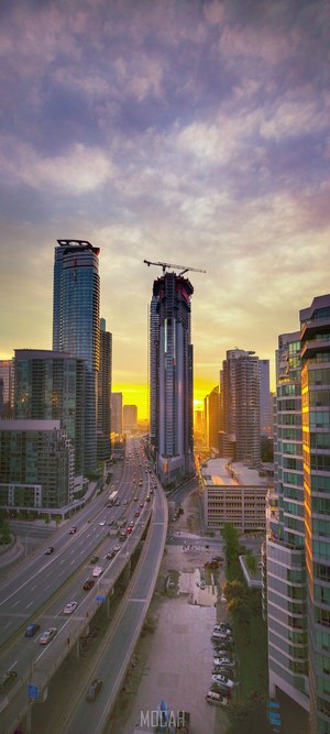 Cityscape with skyscrapers and highway at sunrise
