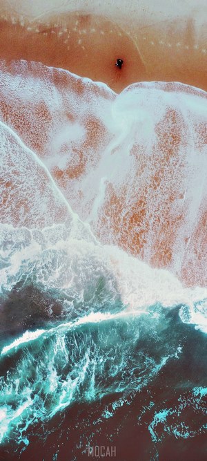 Aerial view of a person on a beach with waves