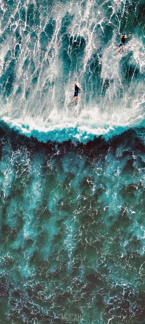 Surfers riding a wave in the ocean