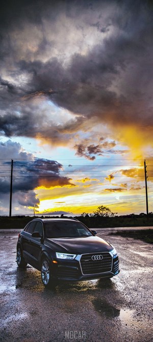 Black Audi Q3 on wet road during sunset