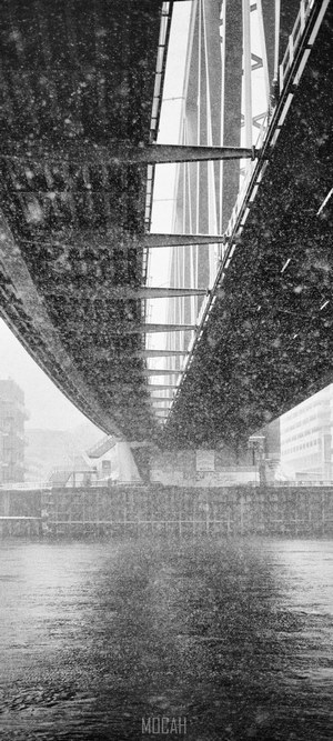 Under a bridge during snowfall