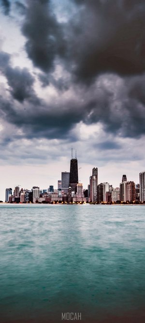 Chicago skyline over water with dark clouds