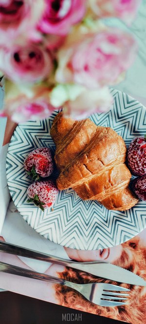 Croissants and strawberries on a plate with flowers