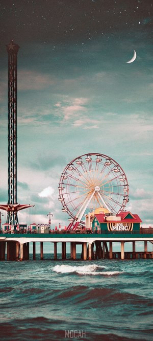 Amusement park pier with Ferris wheel and tower at night