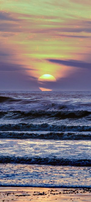Sunset over the ocean with waves