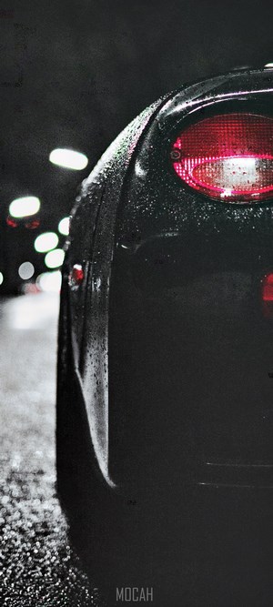 Black car with red taillight in the rain