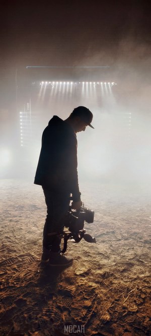 Man with camera in smoke with stage lights