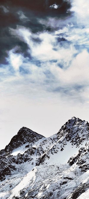 Snowy mountain peak under a cloudy sky
