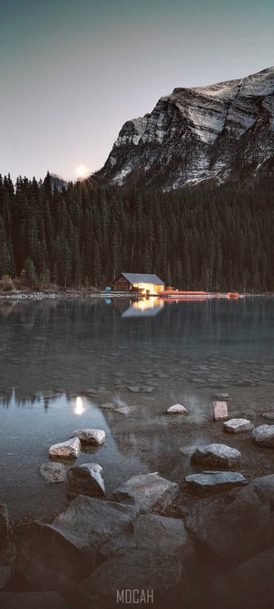 Cabin on a lake with mountains and forest
