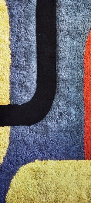 Abstract rug with yellow, blue, black, and orange shapes