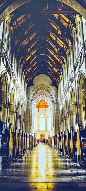Interior of a grand church with a person standing at the altar