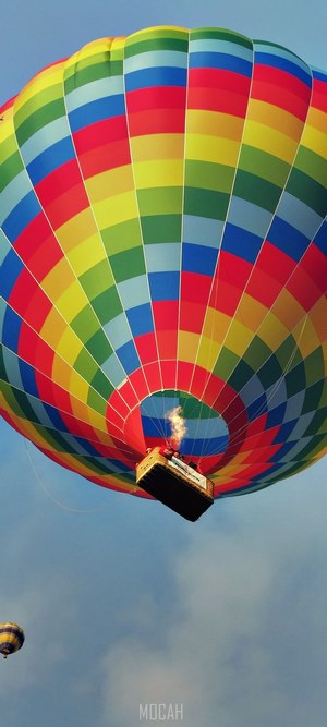 Colorful hot air balloon with flame in sky