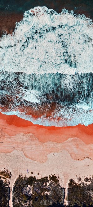Aerial view of ocean waves crashing on a sandy beach