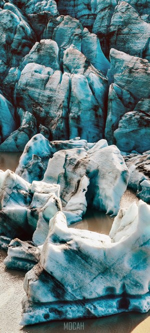 Blue glacier with icebergs and water