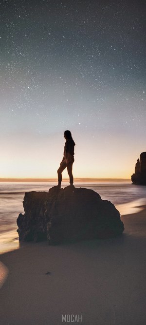 Woman standing on rock at Great Ocean Road under stars