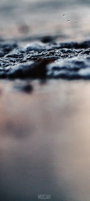 Ocean bubbles on a dark surface with reflection