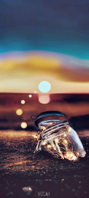 Jar with lights on the beach at sunset