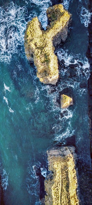 Aerial view of rocky sea stacks and ocean waves