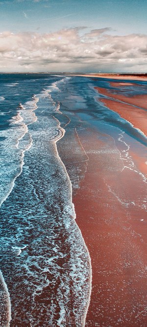 Aerial view of ocean waves on a sandy beach