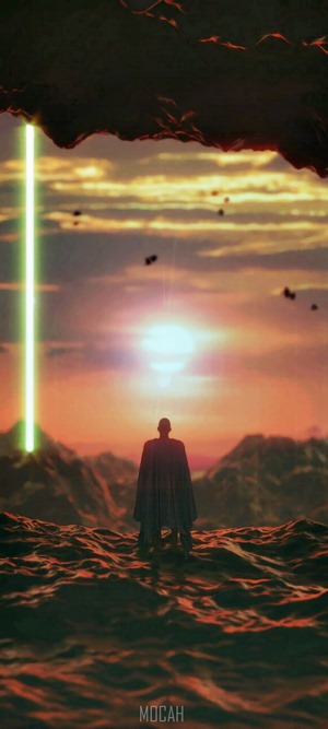 Man in cape facing sunset with light beam