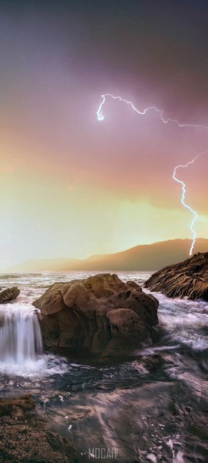 Lightning strike over rocky coast at Laguna Beach, California
