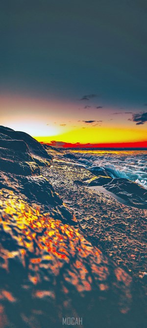 Sunset over rocky shore with ocean waves