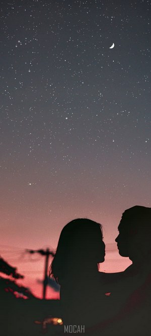 Couple silhouetted against a starry twilight sky