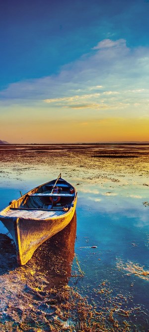 Sunset Reflection with Wooden Boat on Calm Water