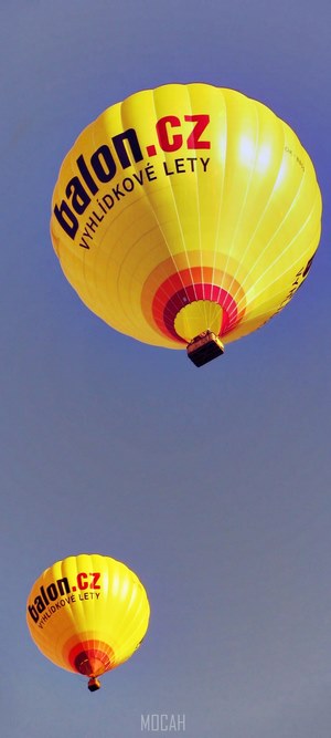 Two yellow hot air balloons flying in the sky