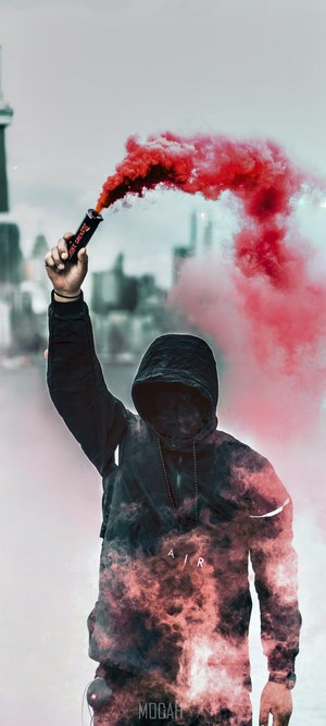 Person holding pink smoke grenade in city