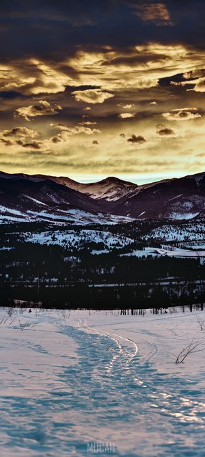 Footprints and ski tracks on a snowy slope in Silverthorne at sunset