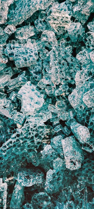 Broken glass shards with teal and blue hues