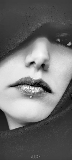 Close-up portrait of a woman's face with a lip piercing