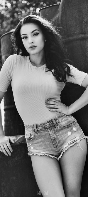 Black and white portrait of a young woman in denim shorts