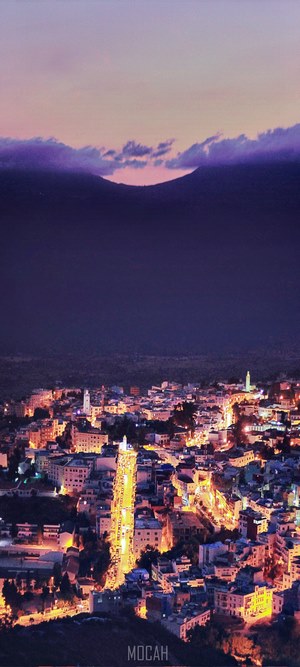 City lights at dusk with mountains