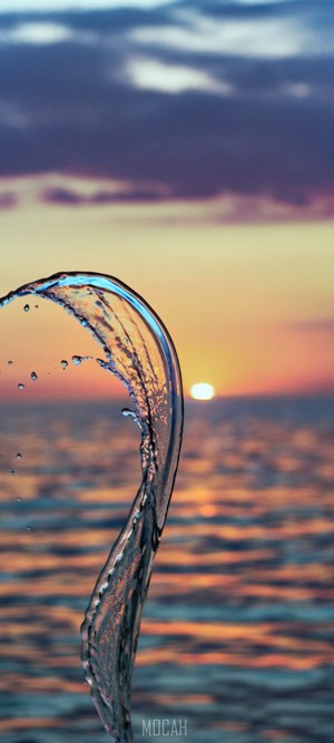 Curved Water Splash at Sunset Over Sea